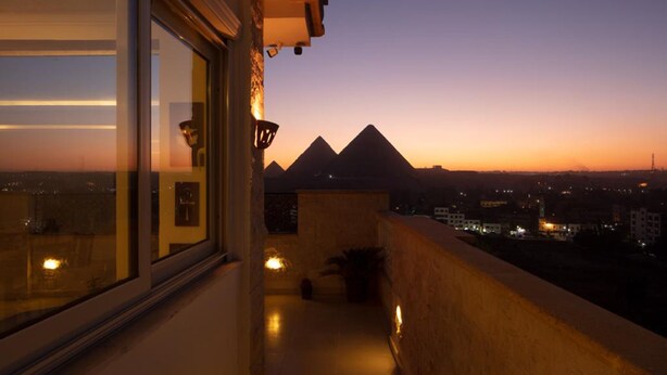 A balcony with a view of the pyramids at sunset. - Pyramids Tower (Giza)