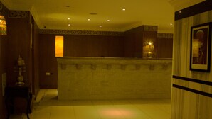 A hotel lobby with a reception desk, a staircase, and a wall with a framed picture. - Pyramids Tower (Giza)
