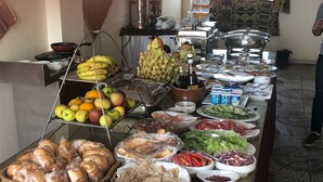 A buffet table with various food items including fruits, vegetables, breads, and condiments. - Pyramids Tower (Giza)