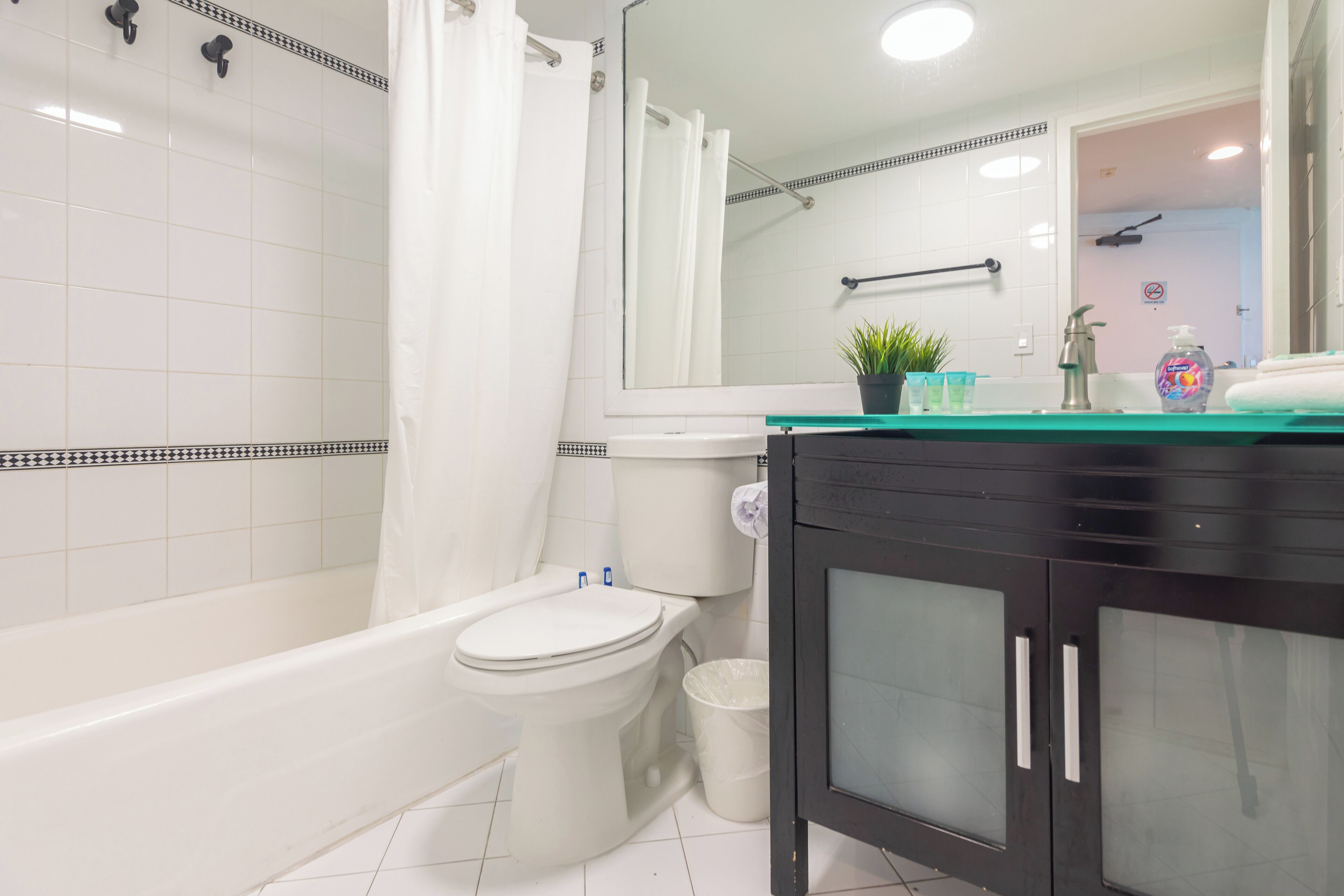 Un bagno moderno con una vasca, un water e un mobile lavabo con specchio.
