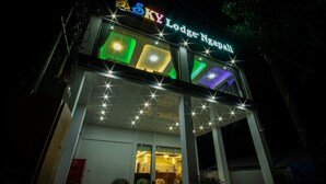 A hotel named "Sky Lodge Ngapali" with a modern facade, illuminated signage, and a welcoming entrance.