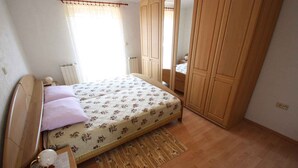 Un dormitorio con cama, armario de madera y radiador.