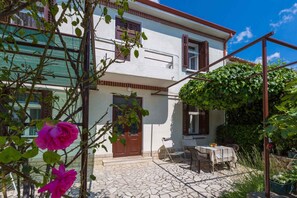 Guests can dine al fresco in the stone-paved courtyard, shaded by a charming pergola.