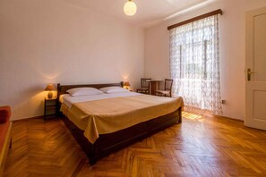 Relax in this serene bedroom with a large bed, two bedside tables, and a comfortable chair.