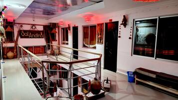 A multi-level interior with a staircase, a sign reading "Sal Andina", and various decorative items.