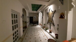 Un couloir doté d’un revêtement de sol à motifs, d’un canapé et d’objets décoratifs, notamment une peau d’animal accrochée au mur.