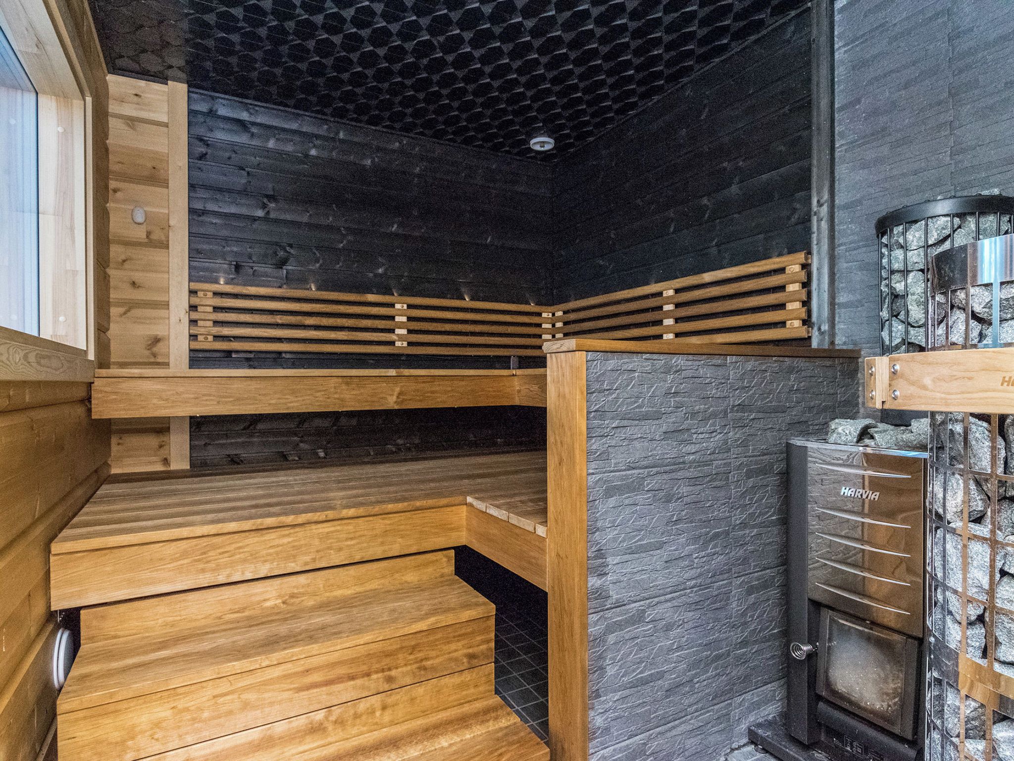 Un interior de madera con una pared de piedra y una chimenea.