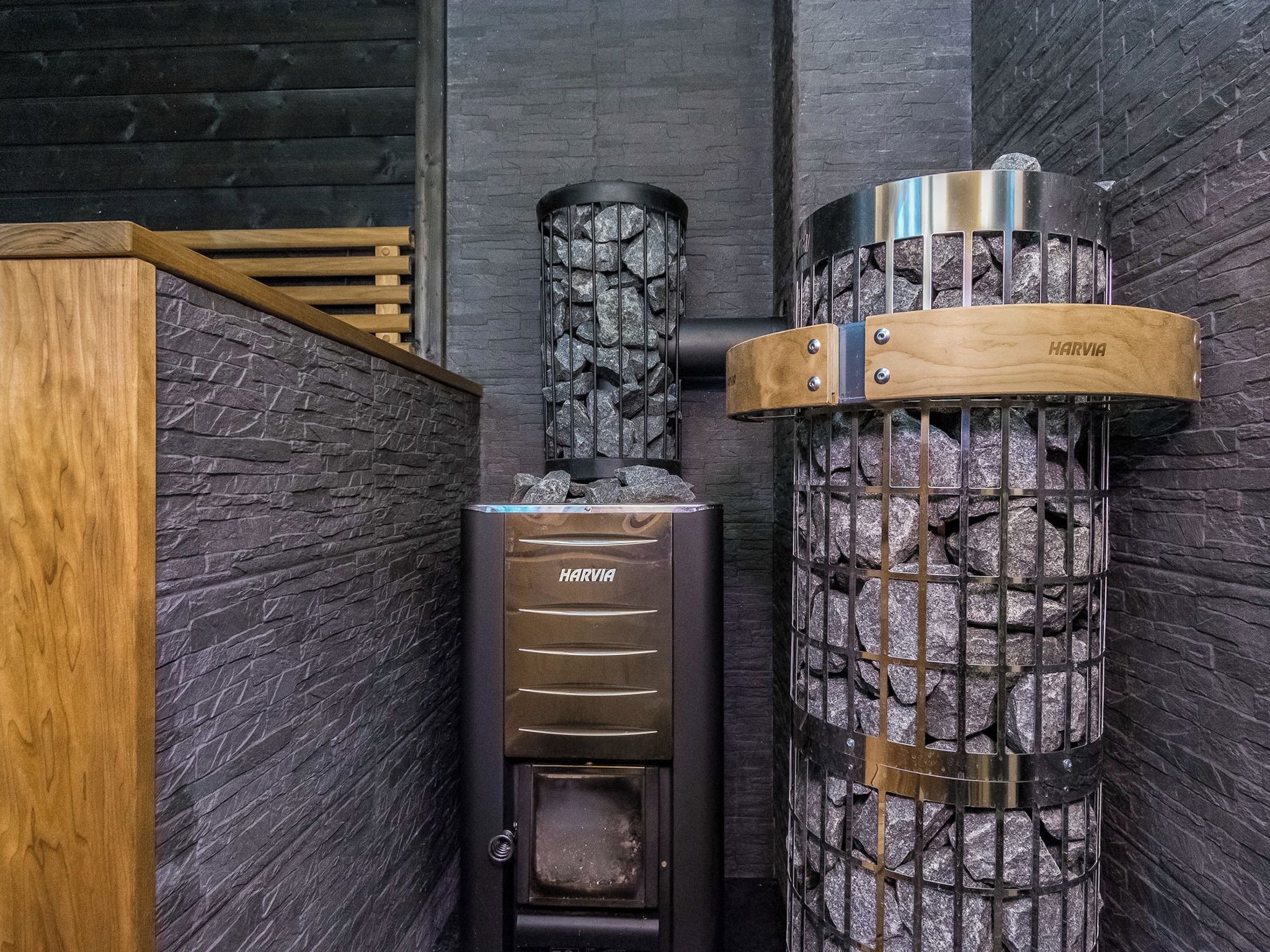 A wood stove with a stone facade and a metal chimney.