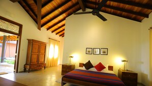 A bedroom with a bed, wooden headboard, nightstands, a ceiling fan, and a wooden cabinet. - Makuludola Bungalow (Malimbada)