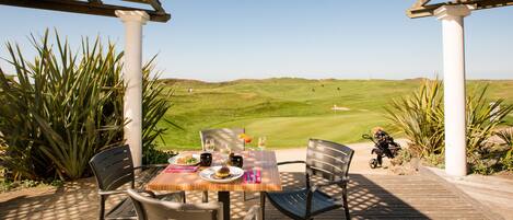 An outdoor dining area with a view of a golf course.