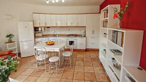 A compact kitchen with white cabinets, a dining table with chairs, a refrigerator, a microwave, and a coffee maker. - May - pretty holiday property with private pool in Benissa (Benissa)