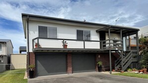 A two-story house with a covered front porch, a garage, and a small outdoor staircase.