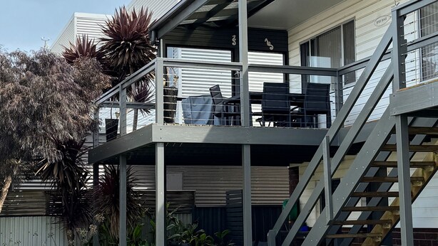 A two-story building with a balcony and a staircase.