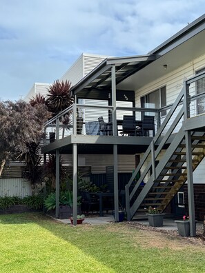 Un immeuble de deux étages doté d’un balcon et d’un escalier.