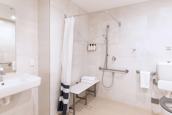 Une salle de bain moderne équipée d’une douche, de toilettes et d’un lavabo.