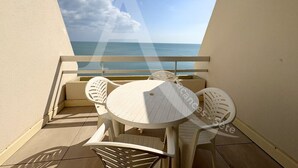 A balcony with a round table and four chairs, overlooking the sea. - STUDIO AVEC PKG, LES CRIQUES DE LA CORNICHE (Sète)