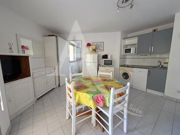 Enjoy meals at the dining table surrounded by comfortable chairs in this well-equipped kitchen.