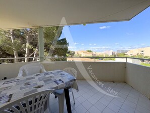 Enjoy dining al fresco with a table set for two on the balcony, offering a view of the surrounding cityscape.