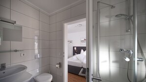 Une salle de bain moderne équipée d’une douche, d’un lavabo et de toilettes.