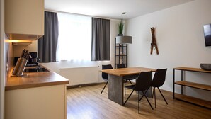 A modern kitchen with a dining area, a radiator, and a plant. - 4802 Cirrus 2 (St. Gallenkirch)