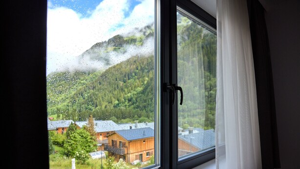 A window with a view of a mountain and a building. - 4802 Cirrus 2 (St. Gallenkirch)
