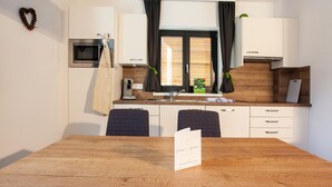 Une cuisine moderne avec une table en bois, un four à micro-ondes et un évier.