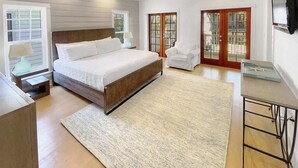 A bedroom with a bed, a chair, a desk, a TV, and a ceiling fan. - Sky Pool/Heated, Fitness & Tennis Center-4 Bikes (Panama City Beach)