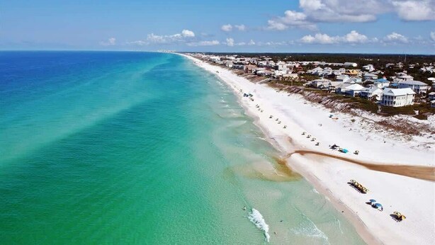 A coastal town with a beach, clear waters, and buildings along the shore. - Sky Pool/Heated, Fitness & Tennis Center-4 Bikes (Panama City Beach)