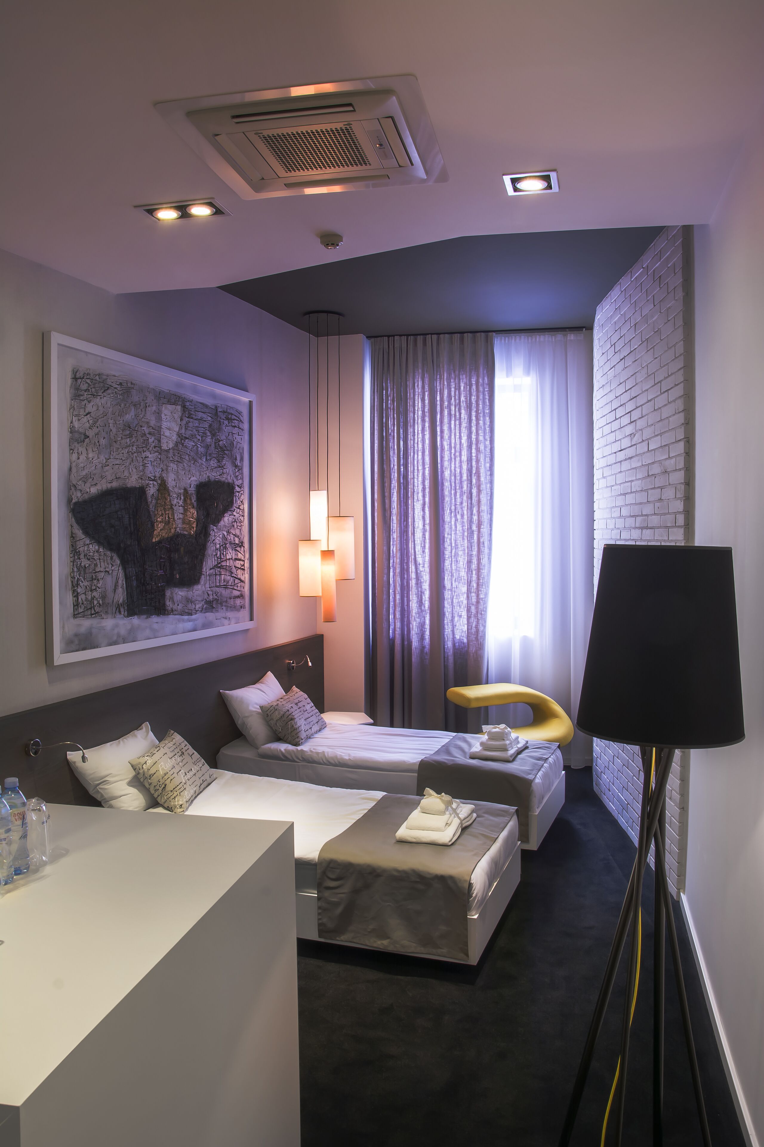 Habitación de hotel con cama, sofá, escritorio y un cuadro grande en la pared.