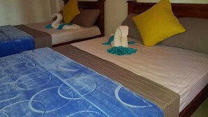 A hotel room with two beds, each with a wooden frame and a blue patterned bedspread. There are pillows on the beds, and a small decorative item on the bed in the foreground. - The Sudbury Villa Nuwaraeliya (Nuwara Eliya)