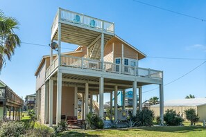 A two-story building with a balcony, a covered outdoor area, and a staircase.