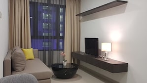 Un saló modern amb un sofà, una taula de caf è negra, una televisió de pantalla plana i una estantenca penjada a la paret.