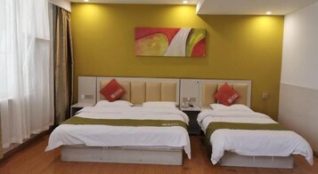 A hotel room with two beds, a large painting on the wall, and a window with curtains.