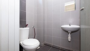 Un baño pequeño y moderno con inodoro, lavabo y espejo.