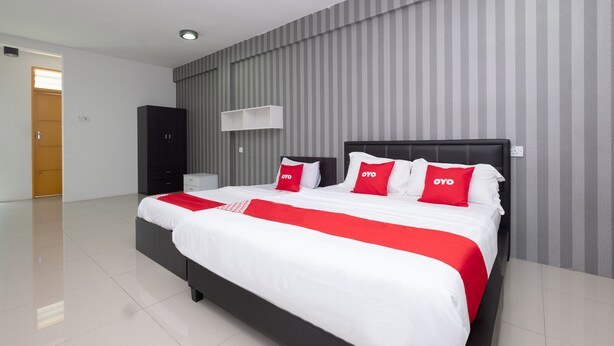 Una habitación de hotel moderna con una cama grande, un armario, una mesita de noche y una pared a rayas.