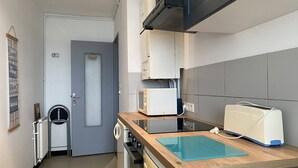 Eine kleine Küche mit Mikrowelle, Toaster und einer Holz Arbeitsplatte.