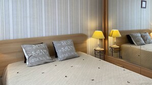 Ein Hotelzimmer mit einem großen Spiegel, zwei Nachttischlampen und zwei Kissen mit Aufschrift.