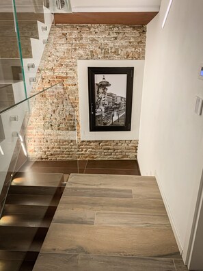 Una escalera con un muro de piedra y una fotografía en blanco y negro enmarcada.