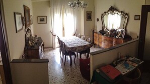 Un comedor con una mesa, sillas, una araña y un espejo.