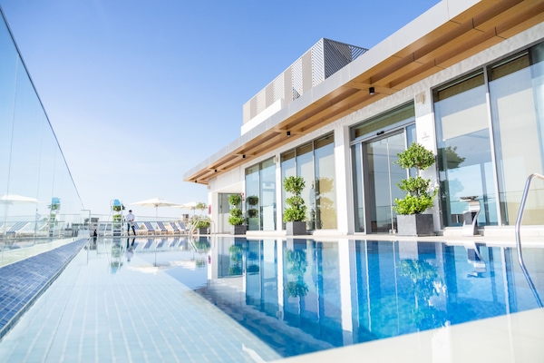 Una piscina al aire libre, sillones reclinables de piscina