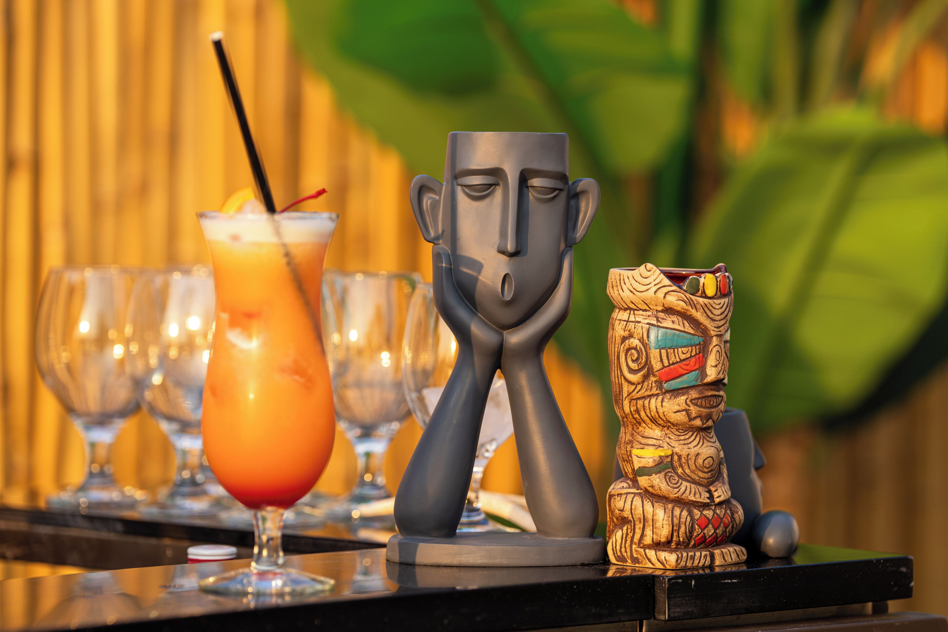 A bar setting with a tiki statue and a cocktail.