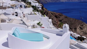 A white building with a blue pool, white walls, and a view of the sea. - Cave Agapi house with private hot tub and view of the Oia caldera (Oia)
