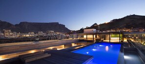 A rooftop pool with a city view, wooden deck, and modern architecture. - Urban Elephant At The Docklands (Cape Town)