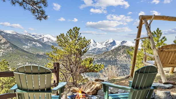 A deck with Adirondack chairs overlooking a mountainous landscape. - Divine Destiny Luxury At Windcliff 6 Bedroom Condo by RedAwning (Estes Park)