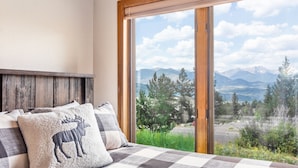 A bedroom with a large window offering a mountain view. - Wanderlust Luxury Vacation At Windcliff 3 Bedroom Condo by RedAwning (Estes Park)