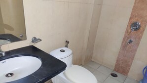 A bathroom with a white toilet, a black sink, and a mirror. - Hotel Trio Tourist (New Delhi)