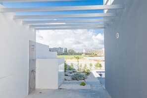 A modern bathroom with a shower, a view of a cityscape, and a small garden area. - Villa Aimee, Contemporary 3BDR Protaras Villa with Pool, Close to The Beach (Protaras)