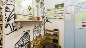 A room with a mirror, a shoe rack, and various informational posters on the walls. - Hotel O Kuantan Backpackers (Kuantan)