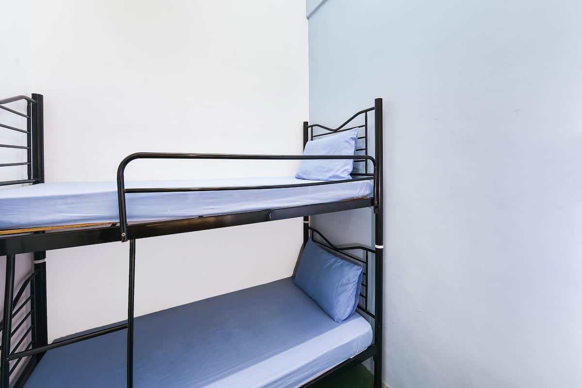 A bunk bed with two levels, each with a mattress and pillow.