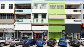 A multi-story building with various shops on the ground floor, including a pharmacy and a convenience store. - Hotel O Kuantan Backpackers (Kuantan)